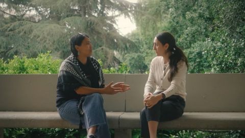 Dues dones parlant entre elles assegudes a un banc.